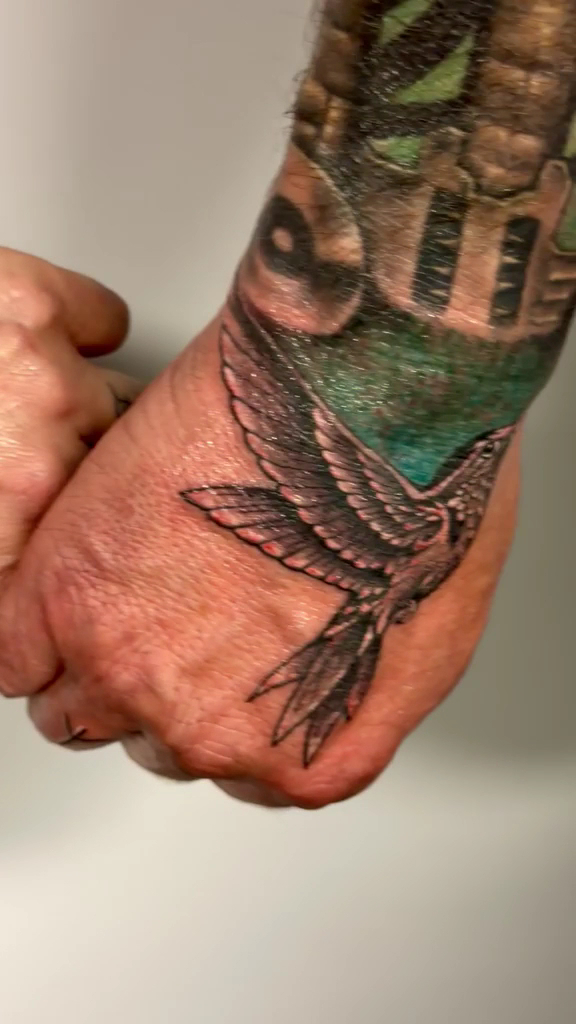Vogel-Tattoo auf Hand und Handgelenk