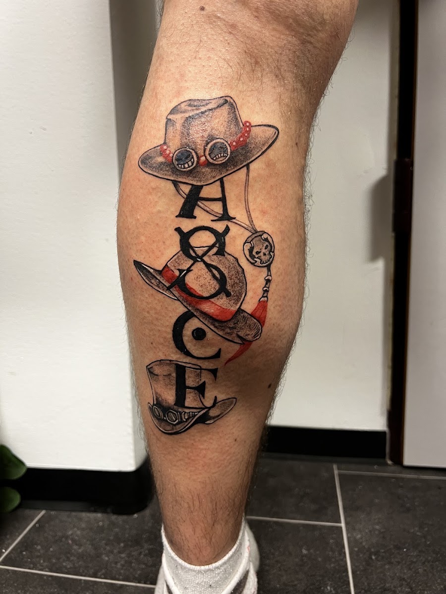 Schriftzug-Tattoo mit Hüten am Unterschenkel